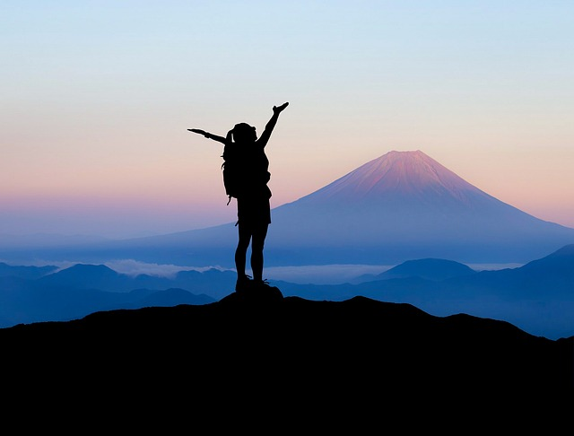 girl stretching her arms on the mountain - Achieving Your Inner Goals