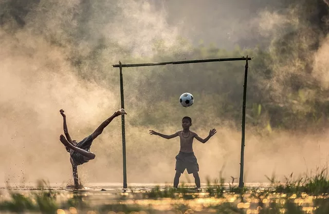 child shooting ball into a goal - representing achieve your goals