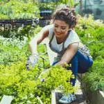 A young lady work in a garden with wearing a white t-shirt and blue pant.