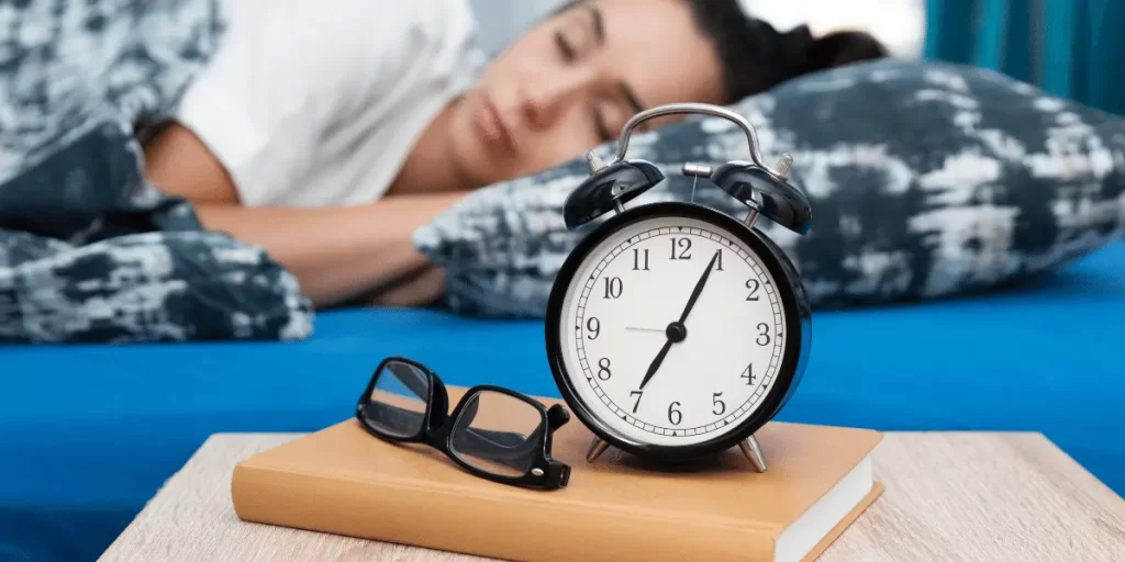 In this image lady sleep after setting a alarm for getting early in the morning