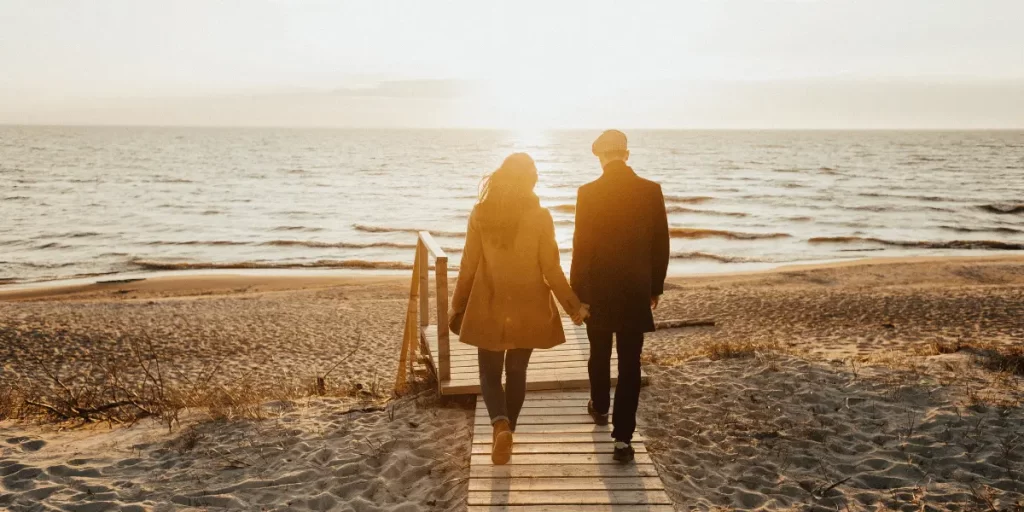 Couples walk on beach 